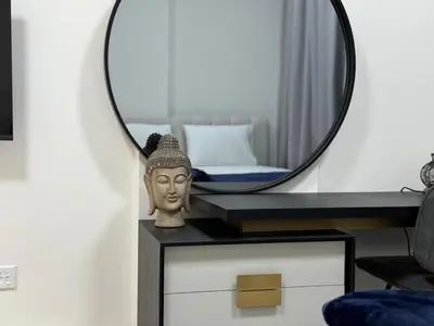 a mirror on top of a dresser with a statue at Sleep 3 Walk to ADCB metro in Dubai