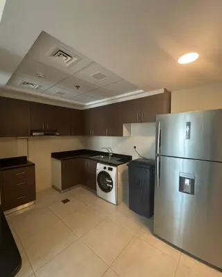 a kitchen with a refrigerator and a washing machine at SAM Homes in Dubai