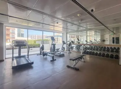 a gym with treadmills and machines in a room at SAM Homes in Dubai