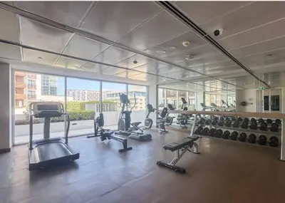 a gym with several treadmills and machines in it at SAM Homes in Dubai