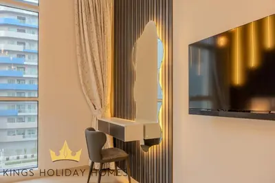 a room with a tv and a chair and a mirror at Royal Suites Dunya Tower Burj Khalifa ST in Dubai