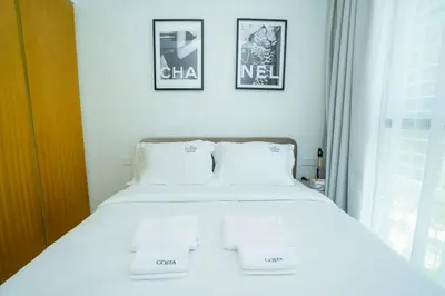 a white bed in a room with two pictures on the wall at High-Floor 2BR - Aykon City 2BR in Business Bay in Dubai