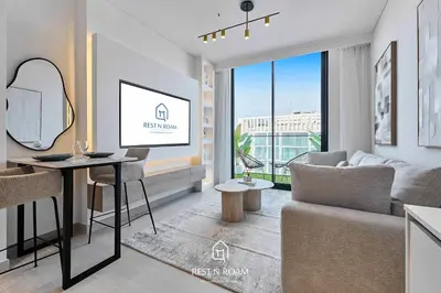 a living room with a couch and a table at Brand New 1BR Near Parks and Mall JVC in Dubai