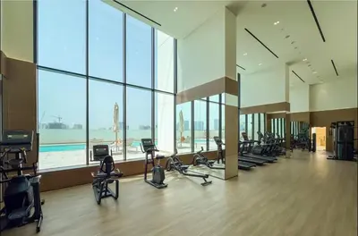 a gym with a lot of treadmills and exercise bikes at Brand New 1BR Near Parks and Mall JVC in Dubai