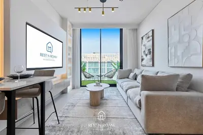 a living room with a couch and a tv at Brand New 1BR Near Parks and Mall JVC in Dubai