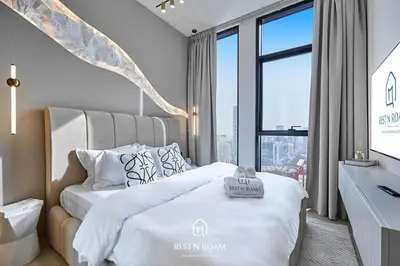 a bedroom with a bed and a large window at Luxury 1B - CityView Near Parks and Mall JVC in Dubai