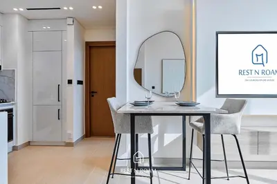 a dining room with a table and a mirror at Luxury 1B - CityView Near Parks and Mall JVC in Dubai