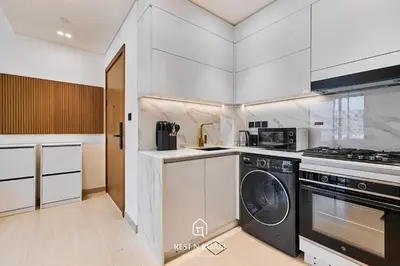 a kitchen with a washer and dryer in it at Binghatti Gardenia 1BR - Near Parks and Mall JVC in Dubai