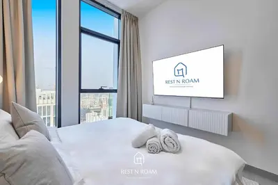 a bedroom with a bed with a flat screen tv at High Floor 1BR - Near Parks and Mall - JVC in Dubai