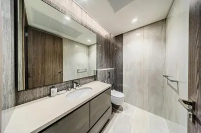 a bathroom with a sink and a mirror and a toilet at Peninsula Five 3BD Duplex with Lake view, For 9 in Dubai
