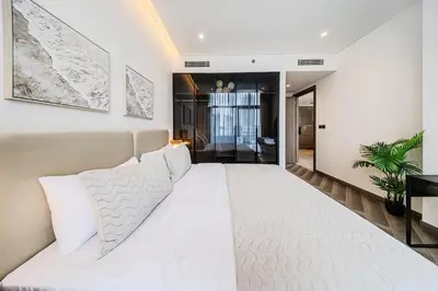 a bedroom with a large white bed with white pillows at Peninsula Five 3BD Duplex with Lake view, For 9 in Dubai