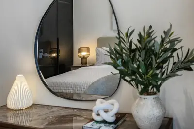 a bedroom with a large mirror and a bed at Peninsula Five 3BD Duplex with Lake view, For 9 in Dubai