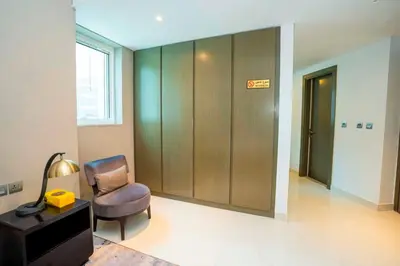 a living room with a chair and a elevator at Charming Studio and Perfect Stay with Gym and Pool in Dubai