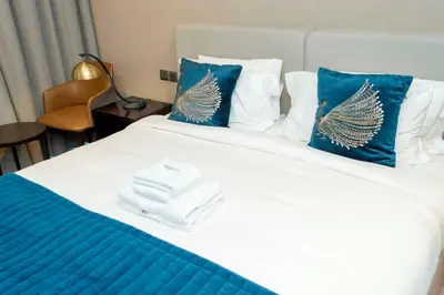 a bed with blue and white pillows and towels on it at Charming Studio and Perfect Stay with Gym and Pool in Dubai