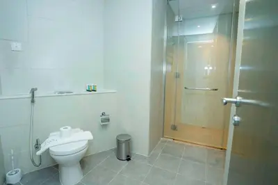 a bathroom with a toilet and a glass shower at Charming Studio and Perfect Stay with Gym and Pool in Dubai