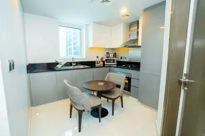 a small kitchen with a table and chairs in it at Charming Studio and Perfect Stay with Gym and Pool in Dubai