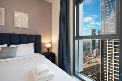 a bedroom with a bed and a large window at Exceptional 2 Bedroom Apartment! High Floor! Amazing Rooftop! Burj Crown by Emaar in Dubai
