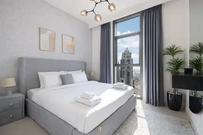 a bedroom with a large bed and a large window at Exceptional 2 Bedroom Apartment! High Floor! Amazing Rooftop! Burj Crown by Emaar in Dubai