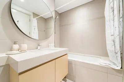 a bathroom with a sink and a mirror at Spacious 4BR Villa with Private Garden & Patio in Nadd Shubayḩ