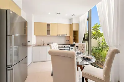 a kitchen and dining room with a table and chairs at Spacious 4BR Villa with Private Garden & Patio in Nadd Shubayḩ
