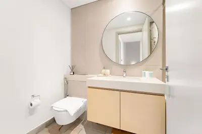 a bathroom with a sink and a mirror at Spacious 4BR Villa with Private Garden & Patio in Nadd Shubayḩ
