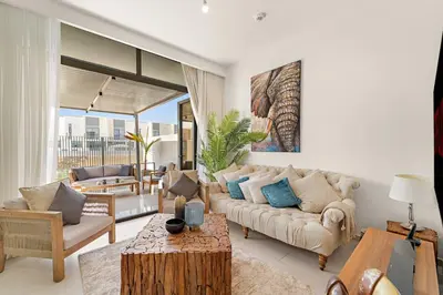 a living room with a couch and a table at Spacious 4BR Villa with Private Garden & Patio in Nadd Shubayḩ