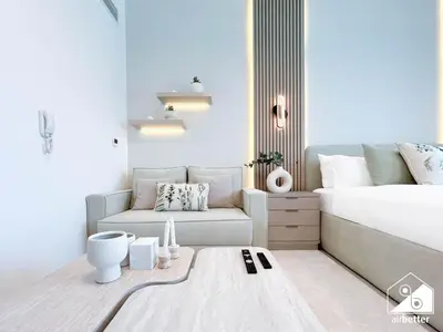 a living room with a bed and a couch at Urban Escape Studio l Pool, Gym & Stylish Living in Dubai