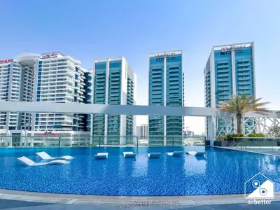 a large swimming pool in front of tall buildings at Urban Escape Studio l Pool, Gym & Stylish Living in Dubai
