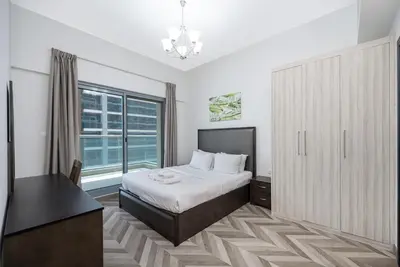 a bedroom with a bed and a large window at Family-Friendly 4BR with Amenities Business Bay in Dubai