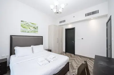 a bedroom with a white bed with two towels on it at Family-Friendly 4BR with Amenities Business Bay in Dubai