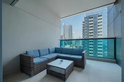 a living room with a blue couch and a large window at Family-Friendly 4BR with Amenities Business Bay in Dubai