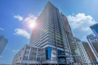 a tall building with the sun in the sky at Family-Friendly 4BR with Amenities Business Bay in Dubai