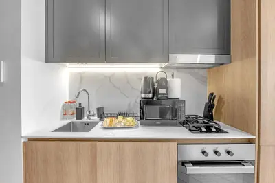 a kitchen with a sink and a microwave at Waves - Modern JVC Studio with Balcony in Dubai