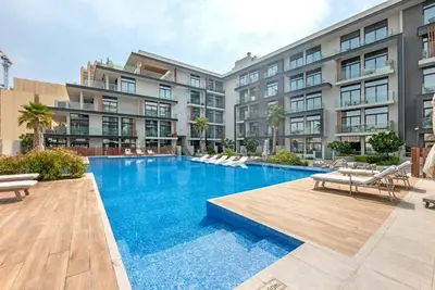 a swimming pool in front of a building at Waves - Modern JVC Studio with Balcony in Dubai