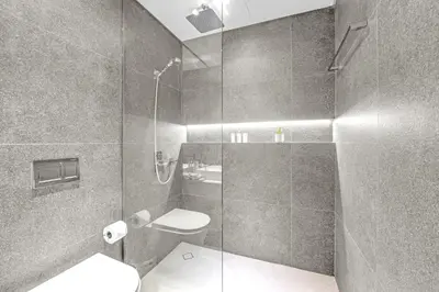 a bathroom with a shower with a toilet and a sink at Waves - Modern JVC Studio with Balcony in Dubai