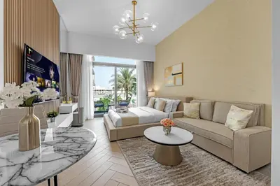 a living room with a couch and a table at Waves - Modern JVC Studio with Balcony in Dubai