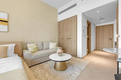 a living room with a couch and a table at Waves - Modern JVC Studio with Balcony in Dubai