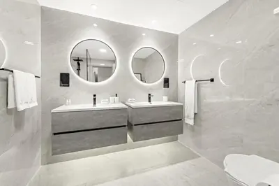a bathroom with two sinks and two mirrors at JBR 3BR Palm Jumeirah & Sea Views, Pool & Gym Access in Dubai