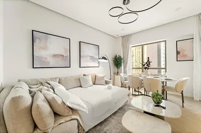 a living room with a couch and a table at JBR 3BR Palm Jumeirah & Sea Views, Pool & Gym Access in Dubai