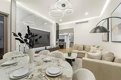 a living room with a dining table and a couch at JBR 3BR Palm Jumeirah & Sea Views, Pool & Gym Access in Dubai