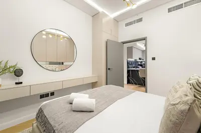 a bedroom with a large mirror and a bed at JBR 3BR Palm Jumeirah & Sea Views, Pool & Gym Access in Dubai