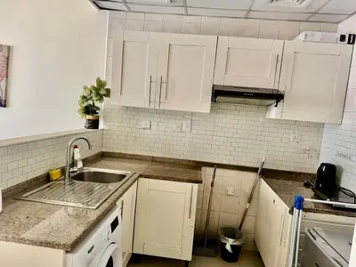 a kitchen with white cabinets and a sink at Not far from metro and WTC in Dubai