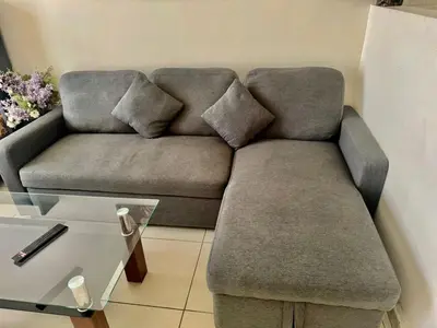 a couch with two pillows on it in a living room at Not far from metro and WTC in Dubai