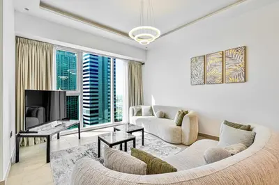 a living room with a couch and a tv at Modern 3BR with City Views and a Spacious Layout in Dubai