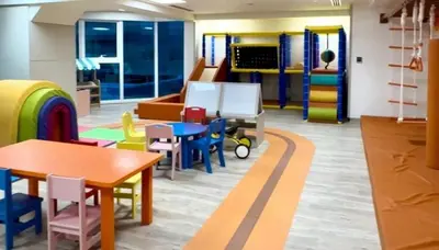 a childrens room with tables and chairs at Modern 3BR with City Views and a Spacious Layout in Dubai