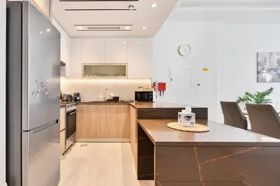 a kitchen with a refrigerator and a counter top at Modern 3BR with City Views and a Spacious Layout in Dubai