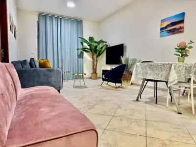 a living room with a couch and a table at Motor City Norton Court Parking Pool in Dubai
