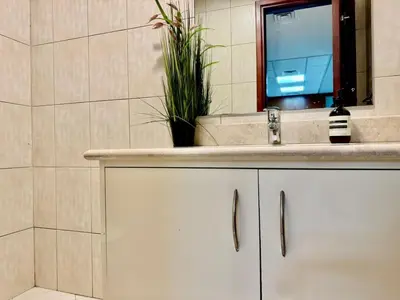a bathroom with a sink and a mirror at Motor City Norton Court Parking Pool in Dubai