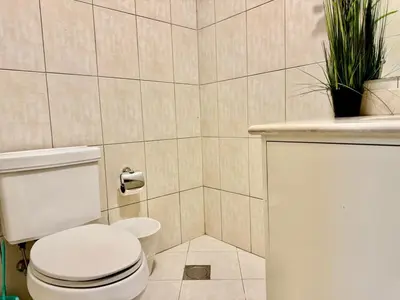 a bathroom with a toilet and plants on the wall at Motor City Norton Court Parking Pool in Dubai