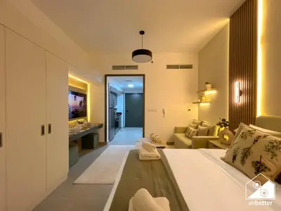 a bedroom with a bed and a living room at High-End Studio l Pool & Gym Included in Dubai
